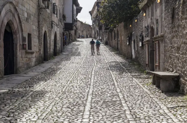 Dos turistas por la calle principal de Santillana del Mar. / ALERTA