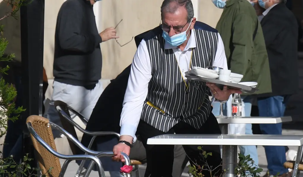 Un camarero prepara una mesa en el centro de Santander. / Hardy