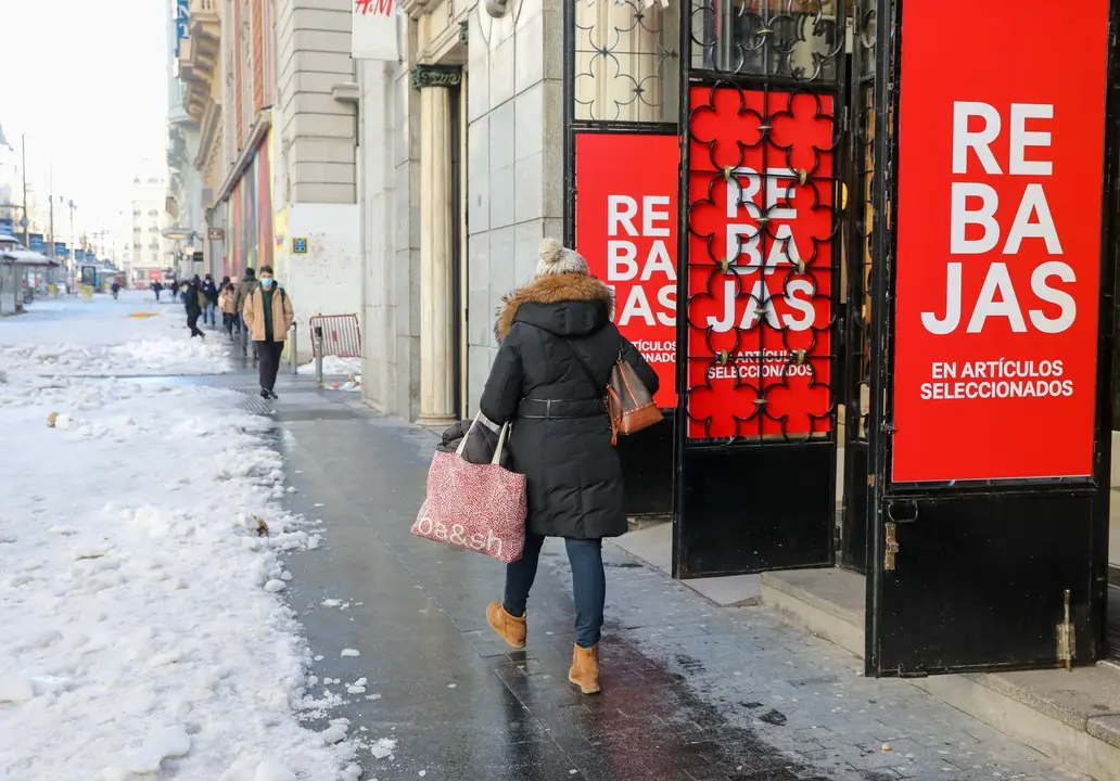 Archivo - Una mujer pasa por delante de un establecimiento durante el s&eacute;ptimo d&iacute;a de las rebajas de invierno, en Madrid