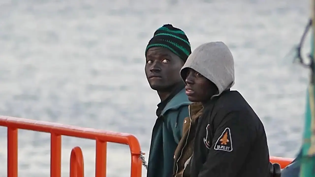 Dos j&oacute;venes migrantes bajan de un barco de la Cruz Roja en el puerto de Arguinegu&iacute;n, en Mog&aacute;n (Gran Canaria, Espa&ntilde;a) 