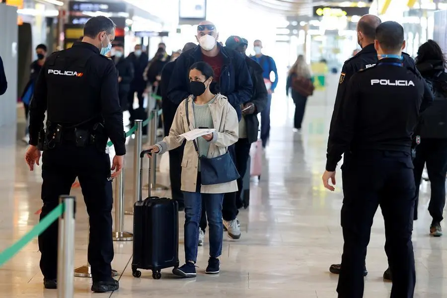 Un polic&iacute;a conversa con una viajera en el aeropuerto Adolfo Su&aacute;rez Madrid-Barajas, este viernes, D&iacute;a de San Jos&eacute;, en Madrid. Puente de San Jos&eacute; en media Espa&ntilde;a con la reducci&oacute;n de la incidencia del coronavirus estancada y todav&iacute;a por encima de los 128 casos por cada 100.000 habitantes; las autoridades sanitarias cruzan los dedos confiando en que los cierres perimetrales y las medidas de restricci&oacute;n adoptadas para los pr&oacute;ximos d&iacute;as permitan que no se invierta la tendencia a la baja. EFE/Chema Moya