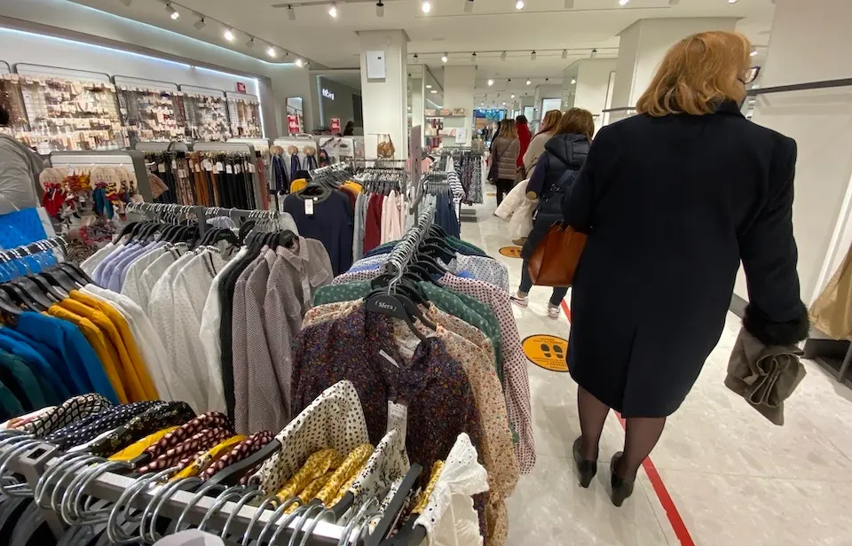 Varias personas hacen cola en un comercio del centro de Santander.