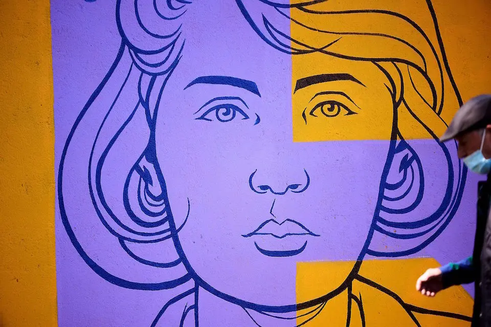 Un hombre pasa delante del mural "Sororidad" que ha confeccionado el Ayuntamiento de Talavera de la Reina en el marco del D&iacute;a Internacional de las Mujeres. / Manu Reino