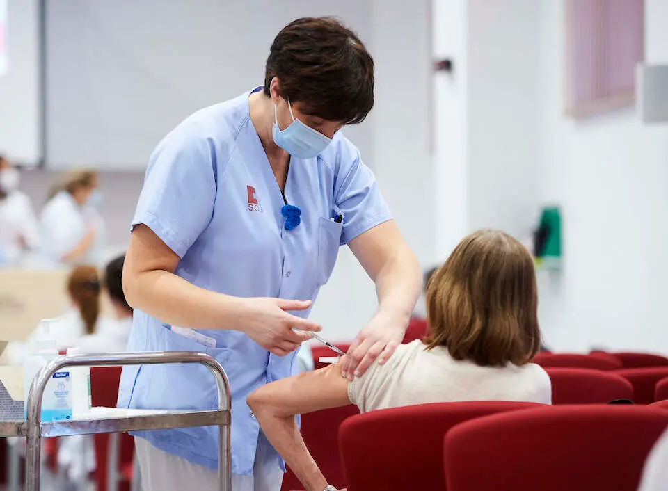 Un trabajadora sanitaria c&aacute;ntabra 
inyecta una dosis de la vacuna contra el coronavirus. / Juan Manuel Serrano Arce
