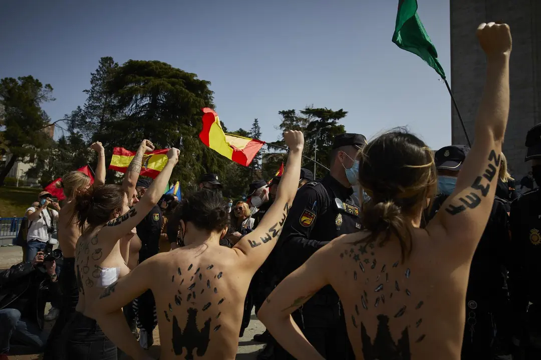 Varias activistas de Femen con &aacute;guilas franquistas dibujadas en la espalda durante un acto por el D&iacute;a de la Victoria en el LXXXII Aniversario de la &ldquo;Liberaci&oacute;n de Madrid&rdquo;, en el Arco de la Victoria, en Madrid (Espa&ntilde;a), a 28 de marzo de 2021.El colectivo a
