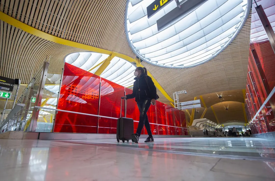 Una pasajera desplaza su maleta por las instalaciones de la T4 del Aeropuerto Adolfo Su&aacute;rez Madrid-Barajas, en Madrid (Espa&ntilde;a), a 26 de marzo de 2021. Un total de 4.818 efectivos de las Fuerzas y Cuerpos de Seguridad del Estado (FCSE) se desplegar&aacute;n esta 
