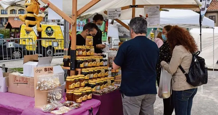 Varios clientes en uno de los puestos de la Feria Agroalimentaria de Pi&eacute;lagos. / ALERTA