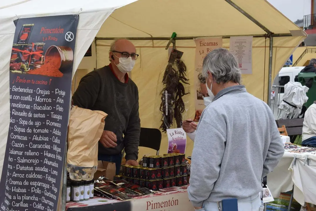 Una persona ojea los productos artesanales en un puesto del mercado de Pi&eacute;lagos en Liencres.