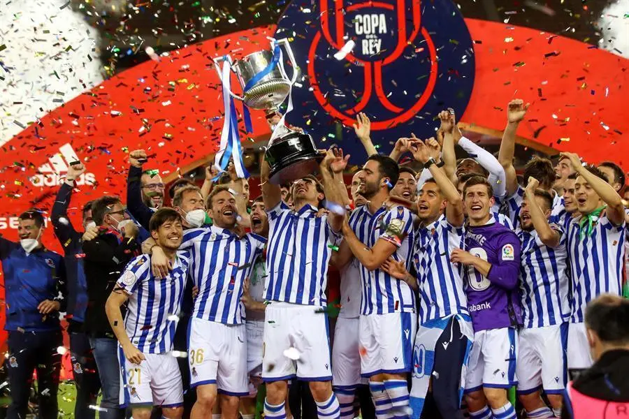 Los jugadores de la Real Sociedad tras recibir el trofeo de manos del Rey Felipe VI de Espa&ntilde;a despu&eacute;s de ganar el partido de la final de la Copa del Rey 2020 de f&uacute;tbol contra el Athletic Club en el estadio de La Cartuja en Sevilla. / RFEF