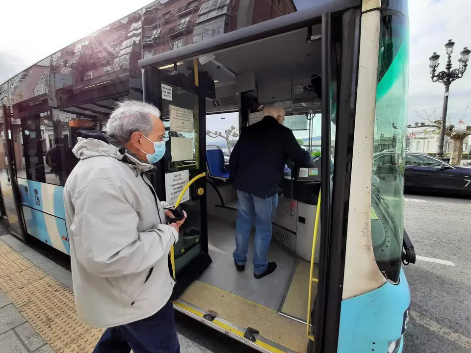 Dos personas con mascarilla suben al autob&uacute;s en Santander. / S. D&iacute;az