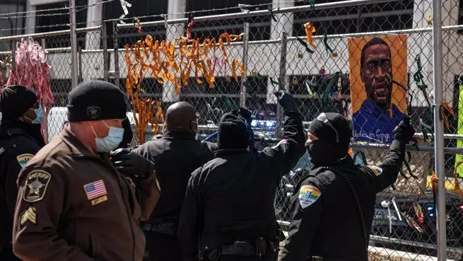 Polic&iacute;as retiran im&aacute;genes de George Floyd en las afueras del juzgado del condado de Hennepin, donde se celebra el juicio por su muerte. - -/imageSPACE via ZUMA Wire/dpa