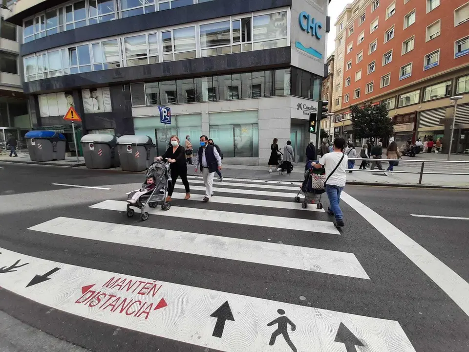 Varias personas cruzan un paso de cebra junto al Ayuntamiento de Santander. / S. D&iacute;az
