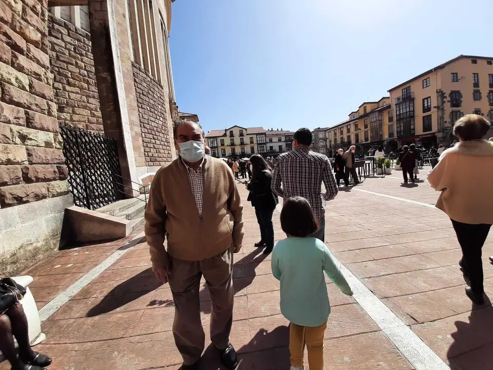 Varias personas con mascarilla transitan por la plaza Roja de Torrelavega. / S. D&iacute;az