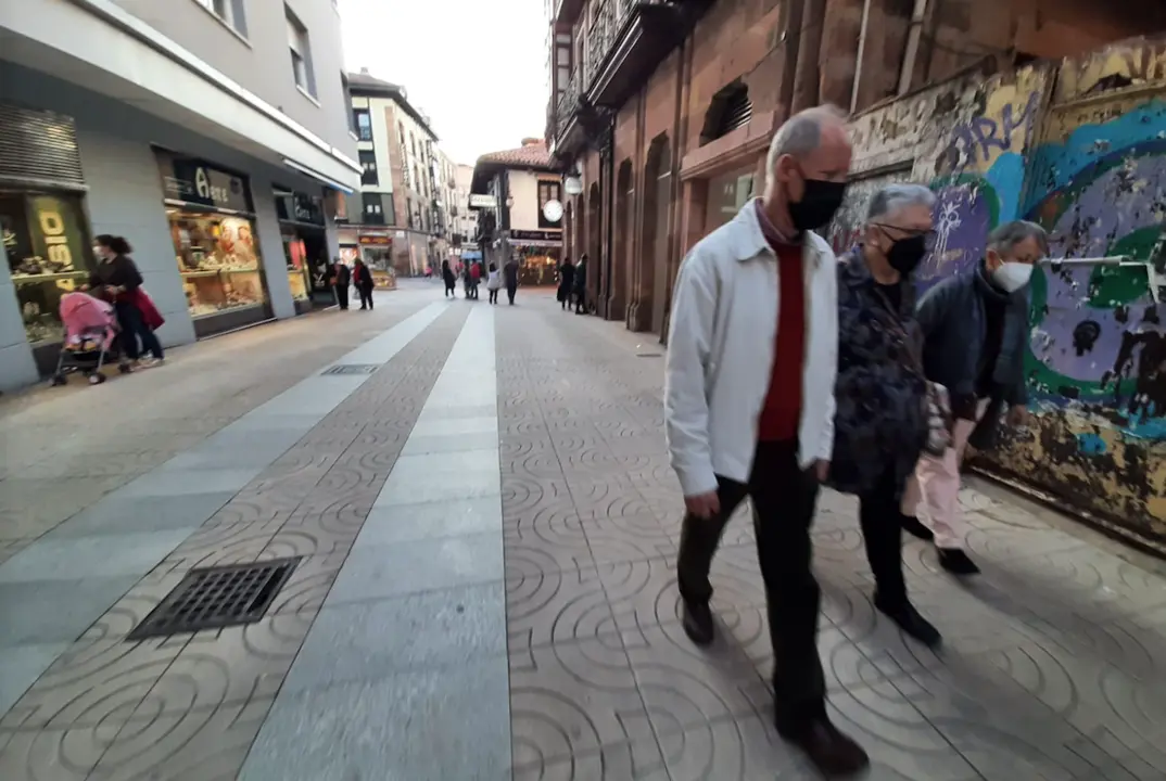Varias personas con mascarilla camina por el centro de Torrelavega. / S. D&iacute;az