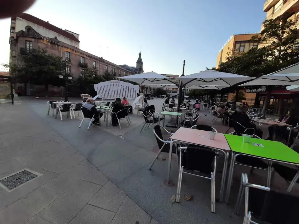 Vista de la terraza con varias personas en la plaza Baldomero Iglesias de Torrelavega. / S. D&iacute;az