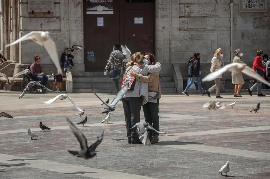 Dos personas se abrazan en una c&eacute;ntrica plaza de Val&egrave;ncia, un gesto d&iacute;f&iacute;cil de ver durante la pandemia, pero que se va recuperando a medida que avanza el proceso de vacunaci&oacute;n cuando la cifra de personas que han recibido ya las dos dosis de la vacuna contra el coronavirus en la Comunitat Valenciana, y por tanto est&aacute;n inmunizadas, se ha situado este martes en las 394.281, con lo que por primera vez supera a la de contagiadas desde el inicio de la pandemia, que son 389.706. EFE/Biel Ali&ntilde;o