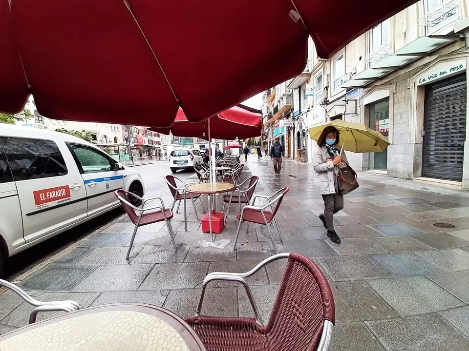 Una persona con mascarilla observa como el fot&oacute;grafo de este medio toma la instant&aacute;nea en el centro de Santander. / S. 
D&iacute;az