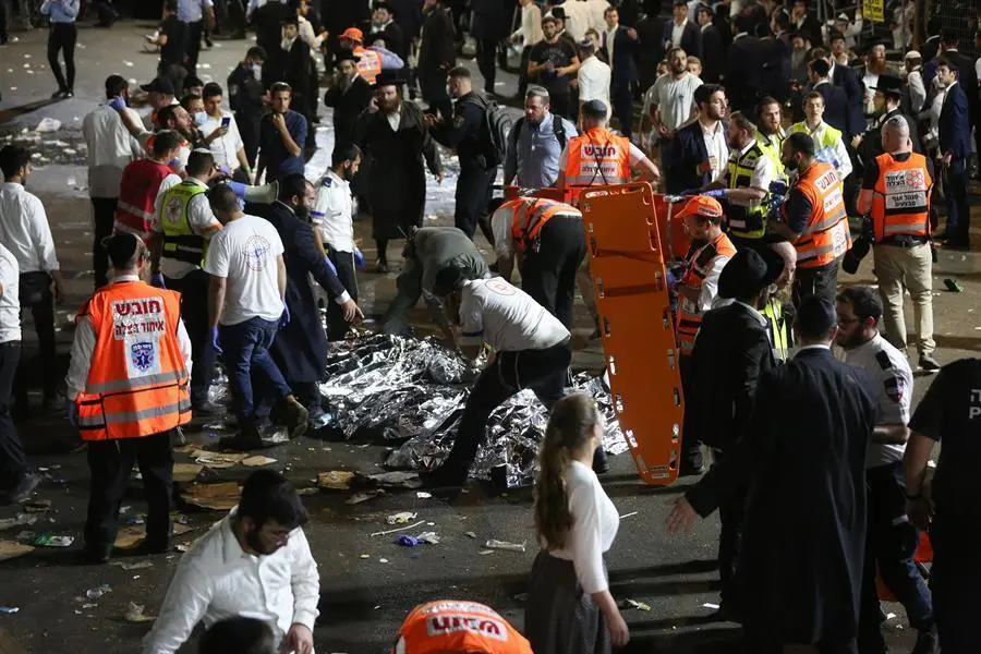 Funcionarios de seguridad israel&iacute;es y rescatistas inspeccionan los cad&aacute;veres de docenas de jud&iacute;os ultraortodoxos que murieron durante un evento en un complejo de juerga durante Lag Ba'Omer; en el Monte Meron, Israel, 29 de abril de 2021. Decenas de personas murieron y resultaron heridas en el complejo de juergas del monte Meron, despu&eacute;s de que se produjera una aparente estampida durante un evento que marcaba el final de la festividad jud&iacute;a de Lag Ba'Omer, el d&iacute;a que marca el aniversario de la muerte del rabino Shimon bar Yochai, un sabio de hace unos 1.800 a&ntilde;os, y el d&iacute;a en que revel&oacute; los secretos de la 'kabbalah', o misticismo jud&iacute;o. EFE/EPA/DAVID COHEN ISRAEL FUERA