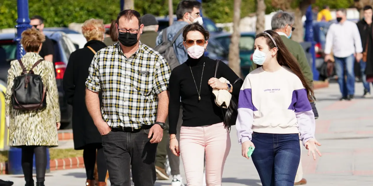 Varias personas transitan con su mascarilla puesta por las inmediaciones de la playa del Sardinero en Santander. / HARDY