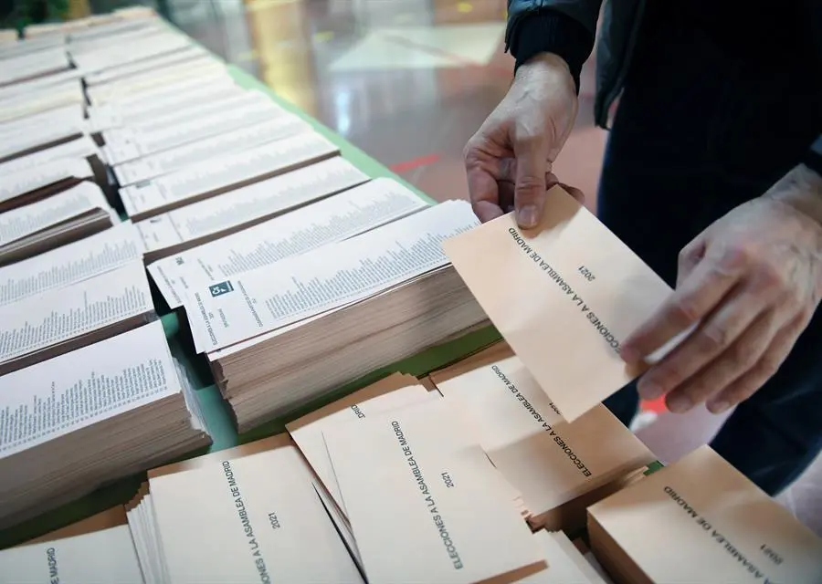 Un miembro de la mesa electoral coloca una mesa con papeletas momentos antes de la apertura del colegio Roma de Madrid, este martes. Un total de 5.112.658 personas est&aacute;n llamadas a votar en las elecciones auton&oacute;micas de Madrid de este 4 de mayo, de las cuales 4.783.528 residen en la regi&oacute;n, una jornada electoral que estar&aacute; marcada por las medidas de protecci&oacute;n contra el coronavirus y por las consecuencias de los resultados no s&oacute;lo en la comunidad aut&oacute;noma sino tambi&eacute;n a nivel nacional. Son unas elecciones singulares en la regi&oacute;n al ser las primeras que se celebran por adelantado y las segundas que tienen lugar en d&iacute;a laborable tras las de 1987, aunque no habr&aacute; clase en los centros no universitarios. EFE/V&iacute;ctor Lerena