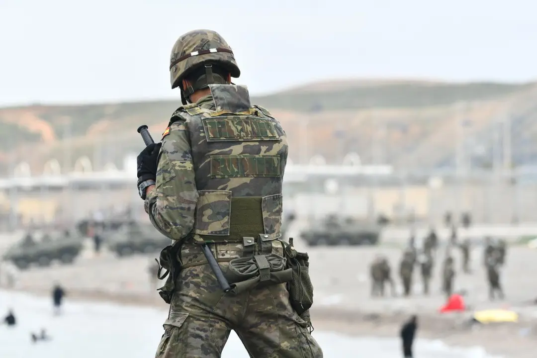Un militar del ej&eacute;rcito espa&ntilde;ol vigila durante las devoluciones en caliente que est&aacute;n efectuando a los migrantes que han entrado en Ceuta procedente de Marruecos