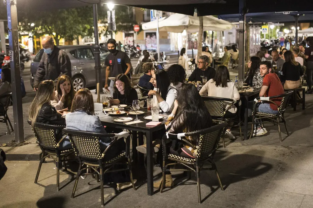 Varios j&oacute;venes sentados en una terraza en la La Latina, zona t&iacute;pica de tapas y copas de la capital, a 14 de mayo de 2021, en Madrid (Espa&ntilde;a). Madrid ha reforzado el dispositivo de la Polic&iacute;a Municipal para este San Isidro, apoyo que ha arrancado a las 20 horas de este viernes y se prolongar&aacute; durante todo el fin de semana. El objetivo del operativo policial es evitar la posible aglomeraci&oacute;n de personas, hacer cumplir la normativa sanitaria y evitar la venta ambulante y el consumo de alcohol en v&iacute;a p&uacute;blica, ha informado el &Aacute;rea de Seguridad y Emergencias del Ayuntamiento de Madrid.