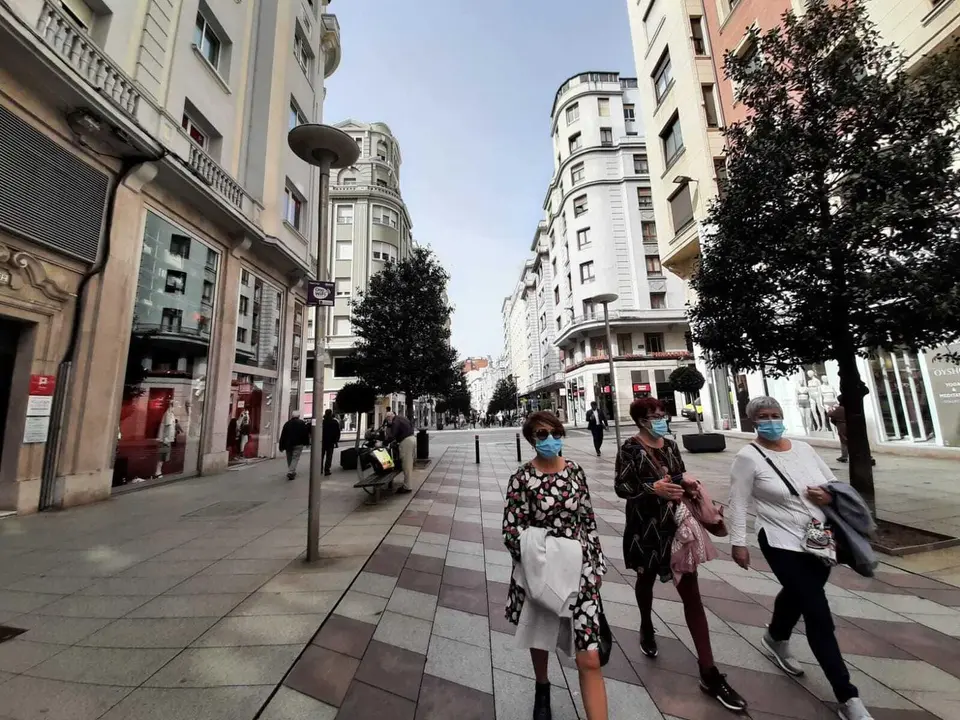Varias personas con mascarilla caminan por una calle del centro de Santander. / S. D&iacute;az
