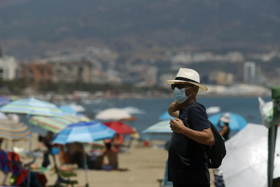 MLG 15-07-2020.-Ba&ntilde;istas disfrutan del d&iacute;a en la playa despu&eacute;s que el gobierno andaluz decretara el uso de la mascarilla obligatorio en todos los espacios, en las im&aacute;genes dichos ba&ntilde;istas en la playa de la Misericordia.-&Aacute;LEX ZEA.