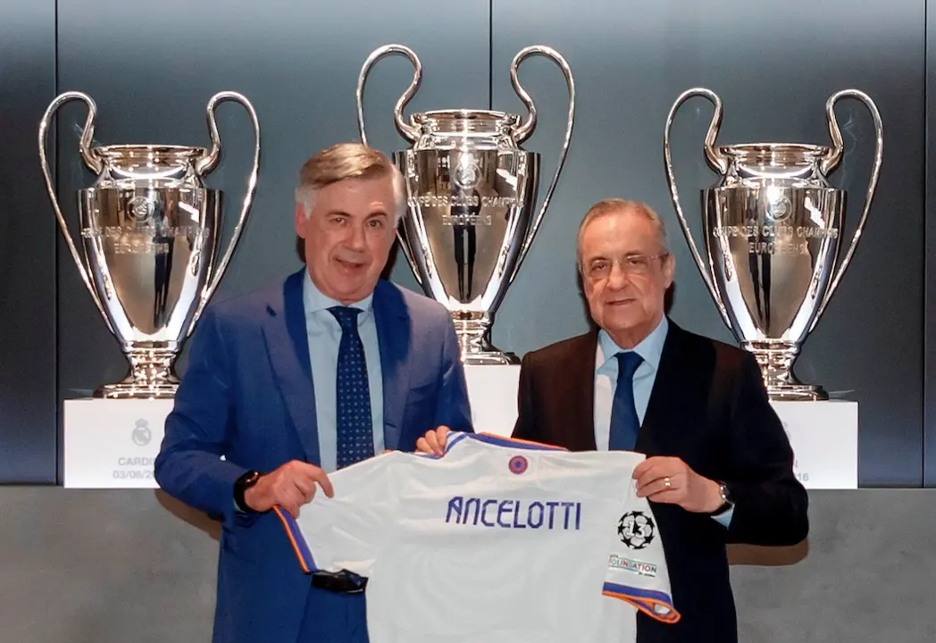 El italiano Carlo Ancelotti (i) posa con el presidente del Real Madrid, Florentino P&eacute;rez, durante su presentaci&oacute;n como nuevo entrenador del club blanco este mi&eacute;rcoles en la sala de prensa de la ciudad deportiva del club blanco, en Madrid. EFE/Real Madrid