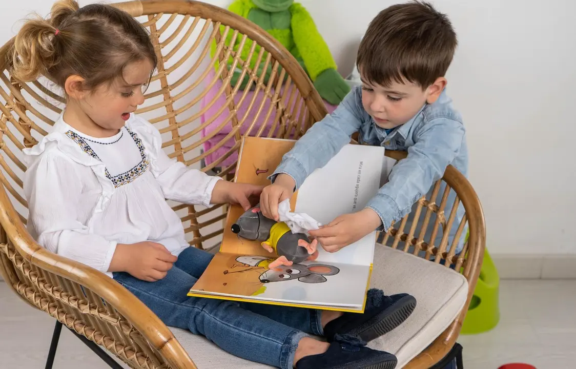Archivo - Dos ni&ntilde;os interactuando con el libro '&iquest;Puedo mirar tu pa&ntilde;al?'