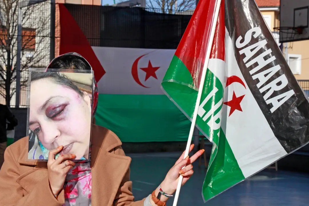 Una mujer con mascarilla levanta la mano con el signo de la paz en la manifestaci&oacute;n por el S&aacute;hara libre en Torrelavega. / J. PALAZUELOS