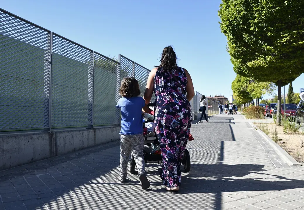 Archivo - Una madre y su hijo empujan el carrito de un beb&eacute; en un parque de Madrid.