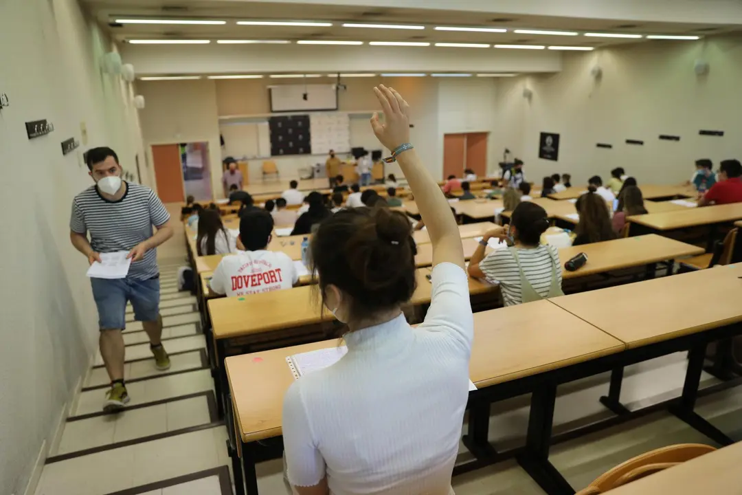 Una estudiante levanta la mano el d&iacute;a del comienzo de los ex&aacute;menes de selectividad 2021.