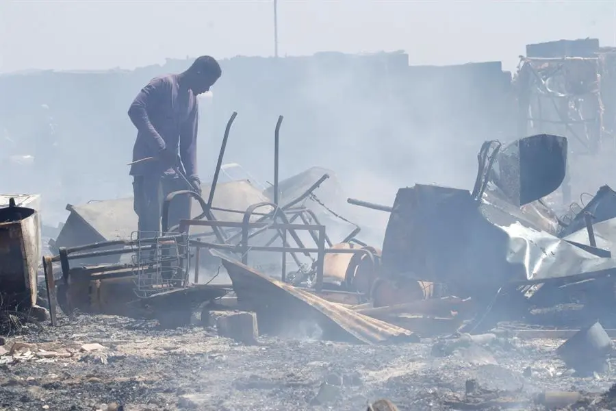 Un hombre busca entre los enseres quemados en el incendio declarado este jueves en un asentamiento de chabolas ubicado At&oacute;chares en el t&eacute;rmino municipal de N&iacute;jar (Almer&iacute;a), en el que han resultado afectadas 80 infraviviendas y detenido un hombre por un delito de hurto.Hasta el lugar han sido movilizados efectivos de los Bomberos de Almer&iacute;a as&iacute; como del Consorcio de Extinci&oacute;n de Incendios del Levante, Protecci&oacute;n Civil, Polic&iacute;a Local y Guardia Civil. EFE/Ricardo Garc&iacute;a