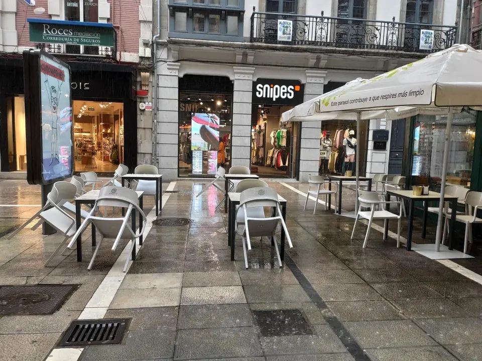 Terrazas vac&iacute;as por la lluvia en las calles de Oviedo