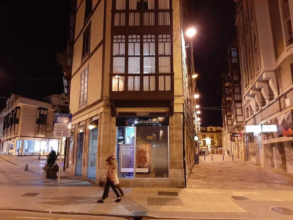 Dos personas camina en la noche de ayer por el centro de Torrelavega. / S. D&iacute;az