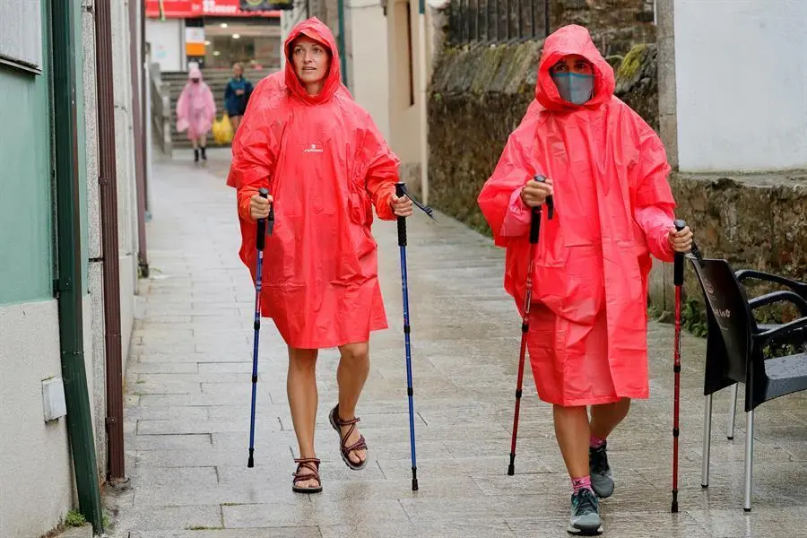 Pregrinos a su paso por Palas de Rei, en Lugo, este martes marcado por las lluvias. La Direcci&oacute;n Xeral de Emerxencias e Interior de la Vicepresidencia de la Xunta de Galicia ha activado una alerta naranja por tormentas y fuertes precipitaciones en las provincias de Lugo y Ourense. EFE/ Eliseo Trigo