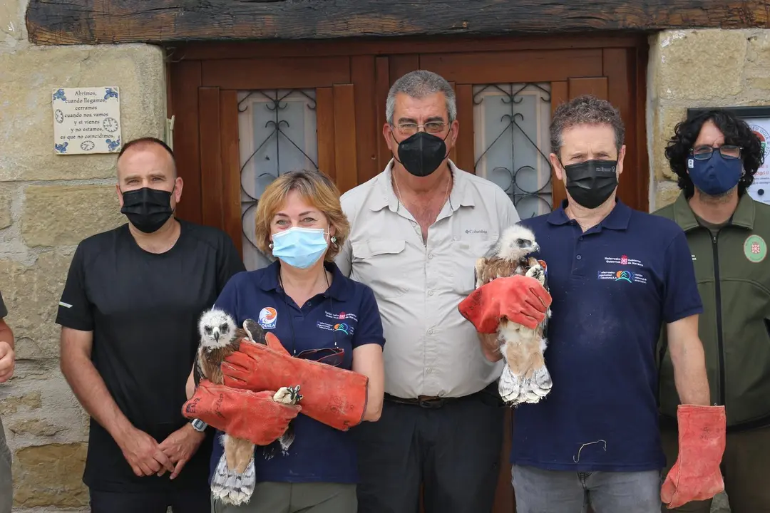 Julia Palacios, t&eacute;cnica del Departamento, y Pablo Mu&ntilde;oz, Director General de Medio Ambiente, con los nuevos ejemplares de &aacute;guila de Bonelli junto a representantes de los cazadores, del ayuntamiento y de Basozainak-Guarderio de Medio Ambiente.