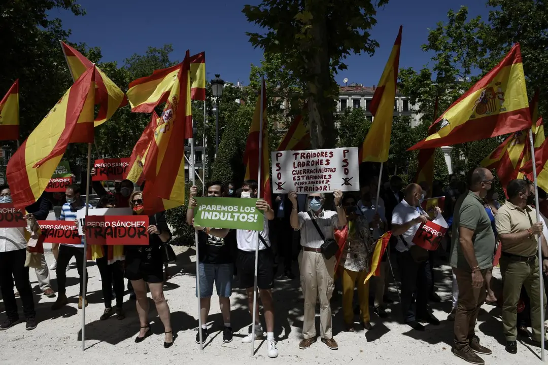 Un grupo de personas se concentra con pancartas y banderas en las inmediaciones del Tribunal Supremo apoyando la querella contra el Consejo de Ministros por la aprobaci&oacute;n de los indultos a los presos independentistas, a 24 de junio de 2021, en Madrid (Esp