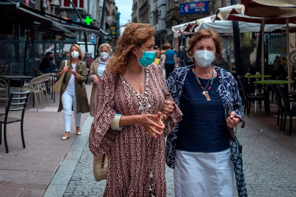 OURENSE, 18/06/2021.- Dos mujeres caminan con mascarilla por una c&Egrave;ntrica calle de Ourense, este viernes. El presidente del Gobierno, Pedro S&middot;nchez, ha anunciado este viernes que la pr&Ucirc;xima semana habr&middot; un Consejo de Ministros extraordinario en el que se decidir&middot; que la mascarilla a causa de la pandemia de coronavirus deje de ser obligatoria en espacios al aire libre a partir del s&middot;bado 26 de junio. EFE/ Brais Lorenzo
