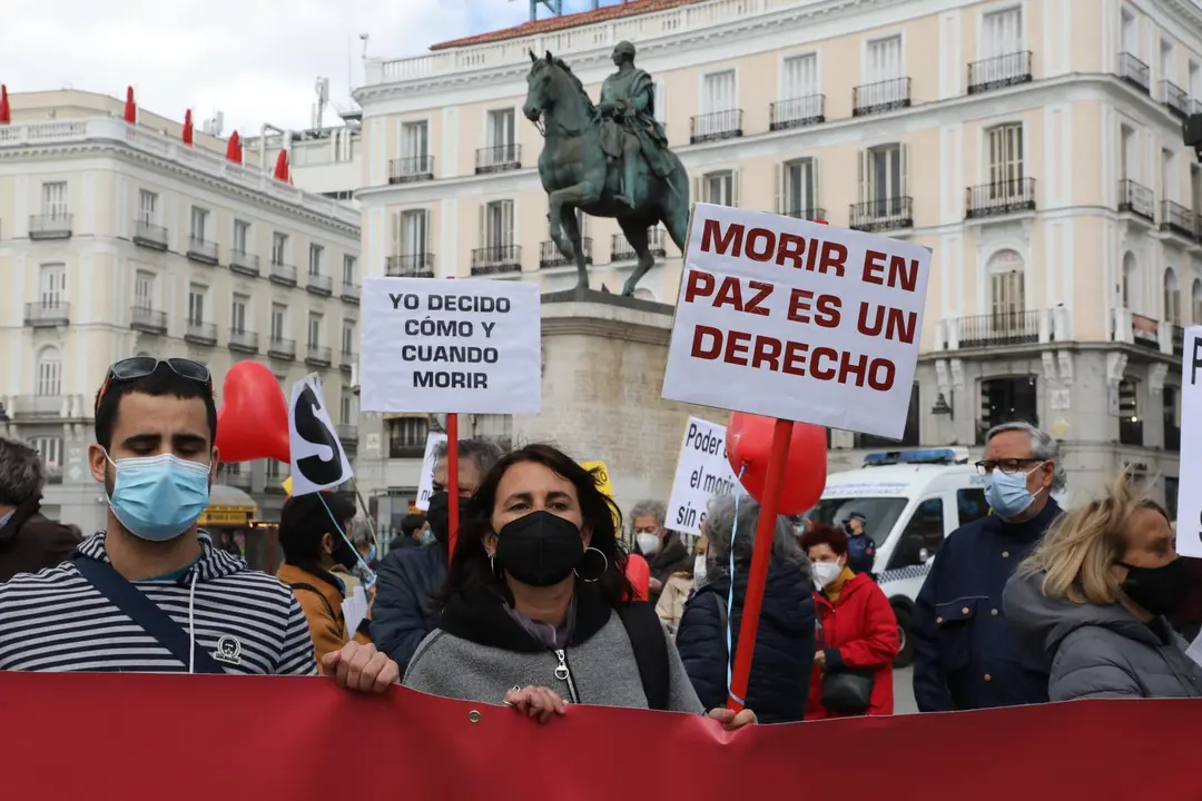 Archivo - Una mujer con un cartel en el que se lee: `Morir en paz es un derecho&acute; durante una concentraci&oacute;n de Derecho a Morir Dignamente en la Puerta del Sol, en Madrid (Espa&ntilde;a), a 18 de marzo de 2021. Derecho a Morir Dignamente se manifiesta para dar apo