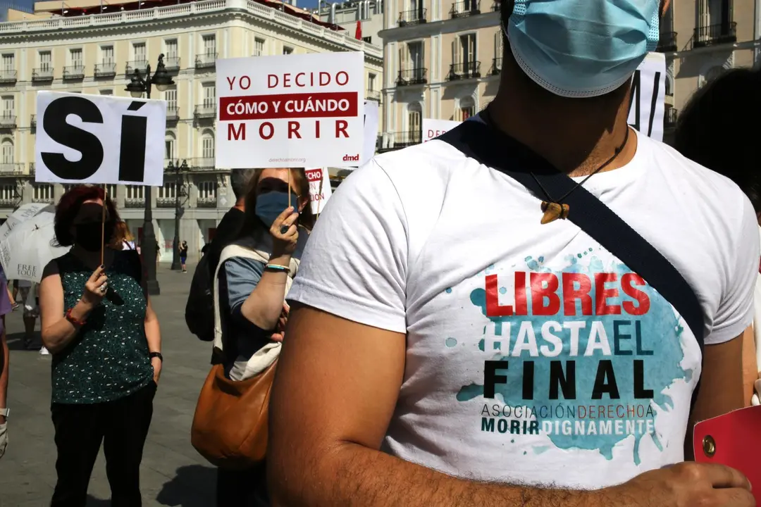 Un grupo de personas se re&uacute;ne sosteniendo pancartas y carteles durante la concentraci&oacute;n de la asociaci&oacute;n Derecho a Morir Dignamente (DMD). 
