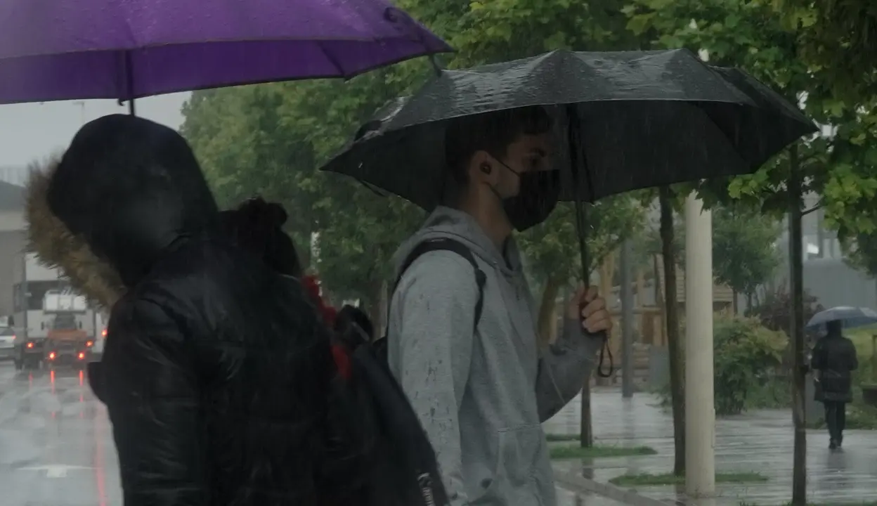 Varias personas bajo lluvia de Santander. / Hardy