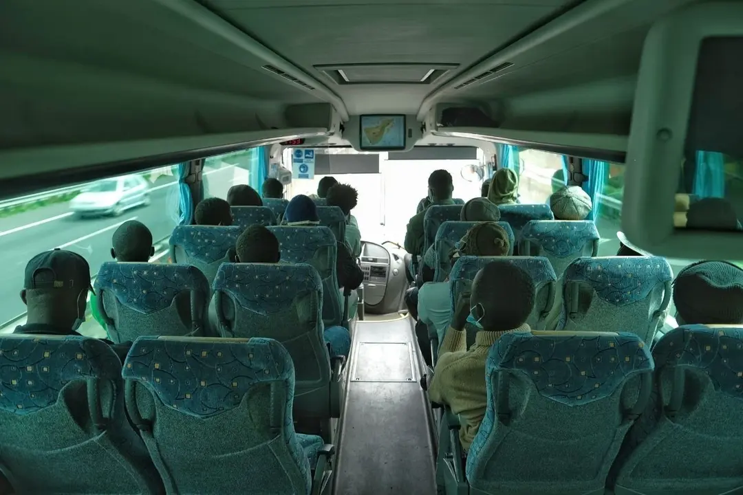 Menores migrantes no acompa&ntilde;ados trasladados en guagua tras el cierre del campamento juvenil de La Esperanza