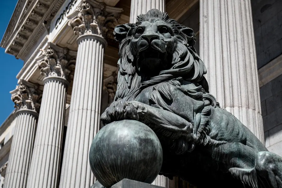 Archivo - Uno de los emblem&aacute;ticos leones que se encuentran delante de la fachada del Congreso de los Diputados en la Plaza de las Cortes de Madrid.