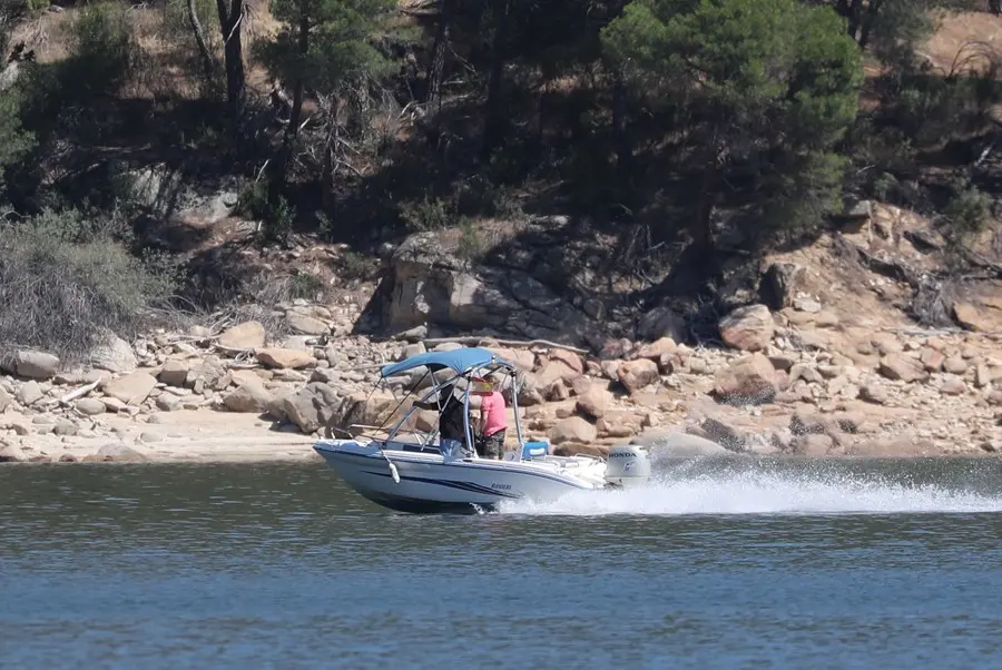 Un grupo de personas montan en una lancha en el pantano de San Juan.