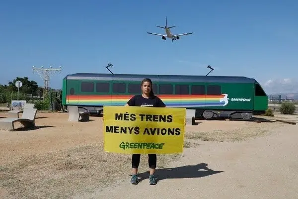 Greenpeace lleva un vag&oacute;n al Aeropuerto de Barcelona para exigir m&aacute;s trenes y menos aviones