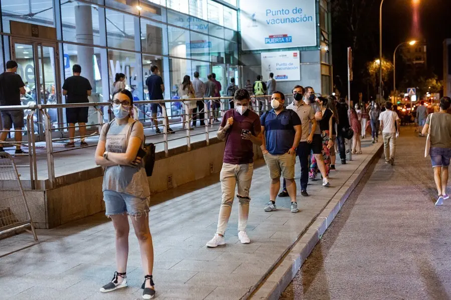 Fila de personas que esperan para recibir una dosis de la vacuna de Pfizer en el Wizink Center