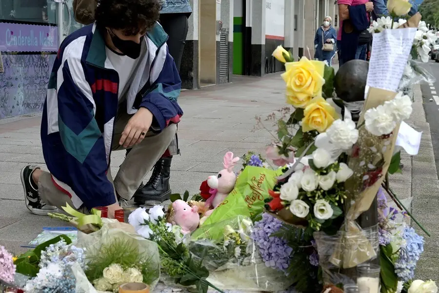 Un joven se arrodilla ante el altar colocado en la acera donde fue golpeado Samuel, el joven asesinado en A Coru&ntilde;a el pasado s&aacute;bado 3 de julio, a 6 de julio de 2021, en A Coru&ntilde;a, Galicia, (Espa&ntilde;a). Familiares, amigos, y vecinos han organizado este altar c