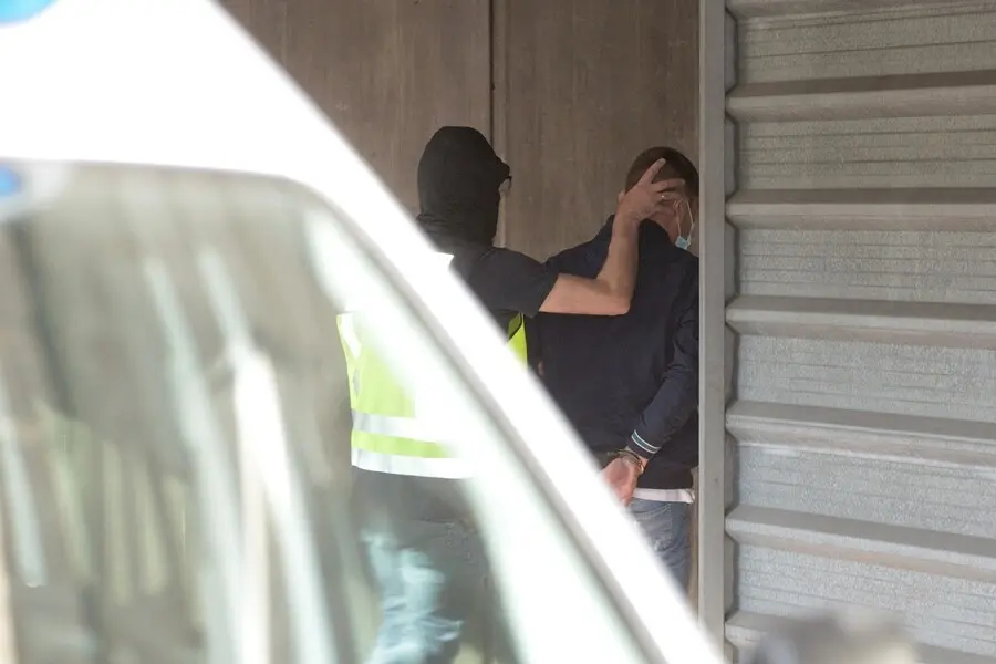 Un agente lleva arrestado a uno de los acusados para declarar como presunto autor de la paliza que caus&oacute; la muerte a Samuel Luiz en A Coru&ntilde;a el pasado 3 de julio